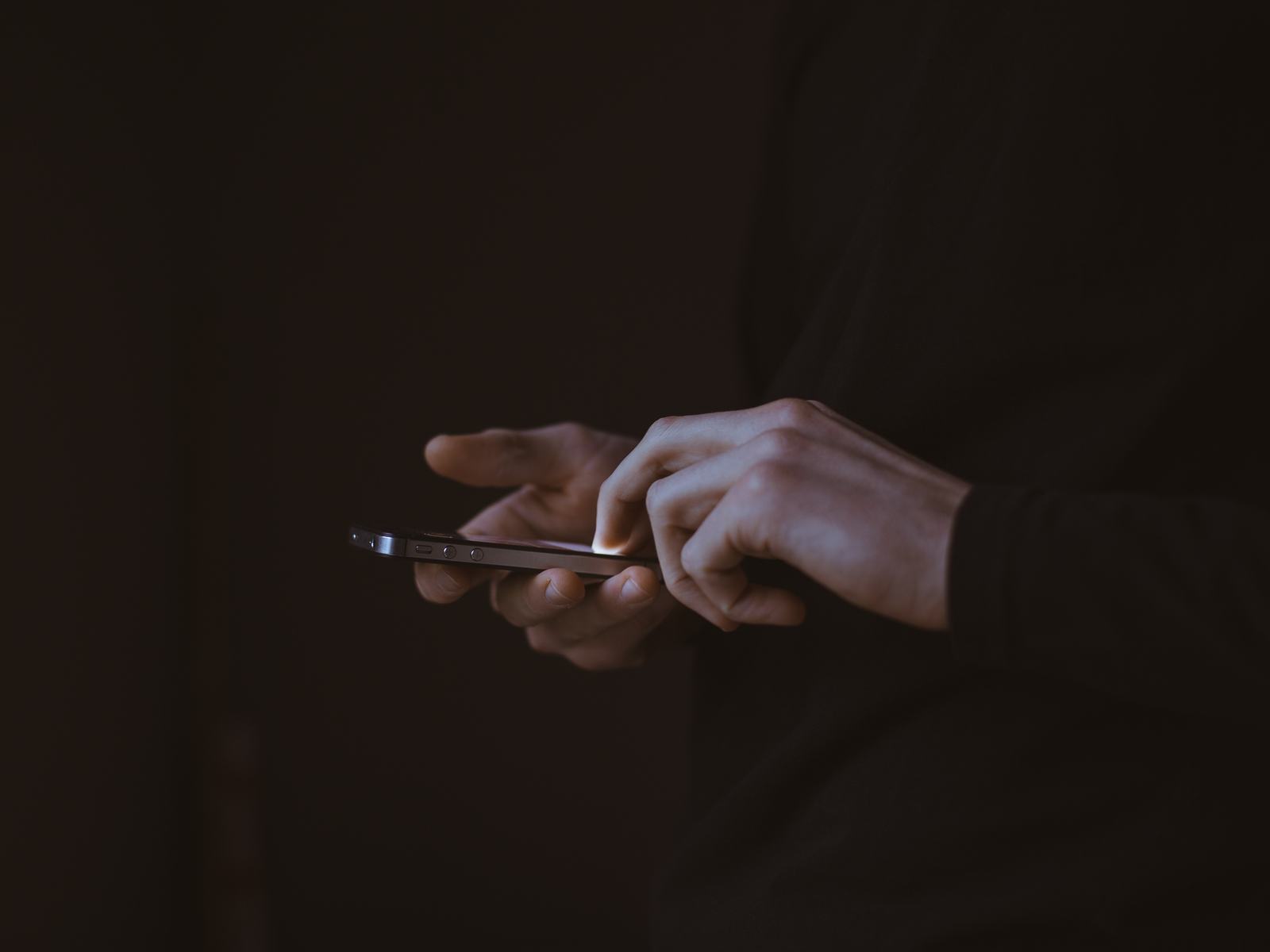Hands using a smartphone in low light