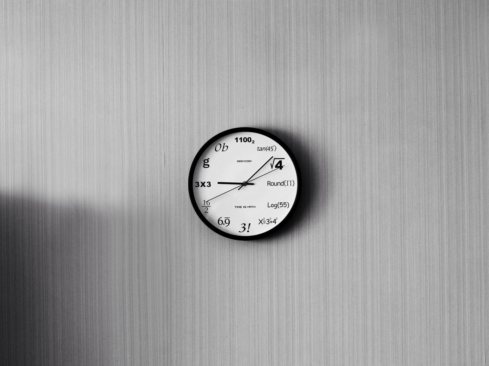 A wall clock on a plain grey wall